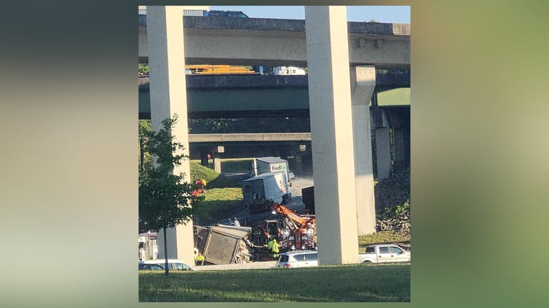 Crews worked to remove the tractor-trailer that overturned and blocked lanes on the I-285 East ramp to I-75 North early Tuesday morning.