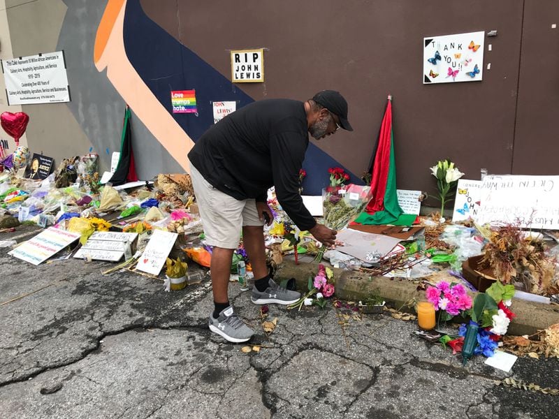 Toronto Thomas of Ellenwood placed a dozen red roses at the base of the Sweet Auburn mural of Congressman John Lewis.