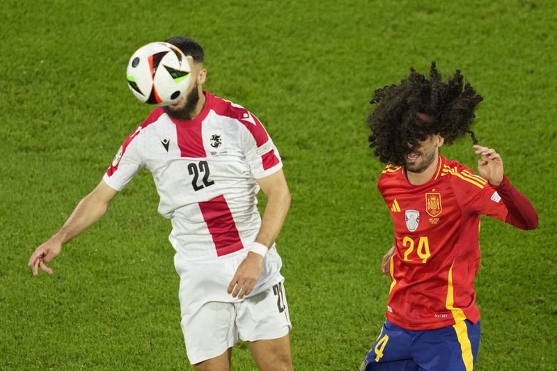 Georgia's Georges Mikautadze, left, challenges for the ball with Spain's Marc Cucurella during a round of sixteen match between Spain and Georgia at the Euro 2024 soccer tournament in Cologne, Germany, Sunday, June 30, 2024. (AP Photo/Andreea Alexandru)