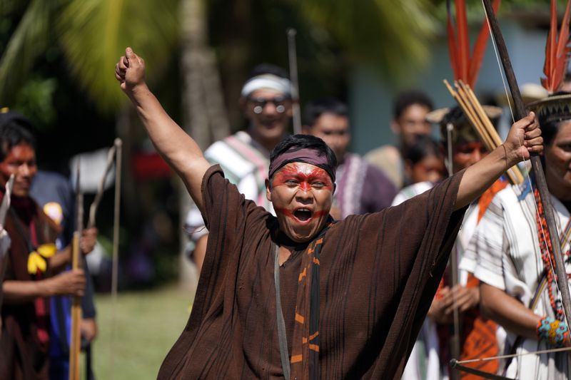 Kamato Ashaninka from Peru reacts to hitting the bullseye in a bow and arrow competition during the annual celebration recognizing the Ashaninka territory in the Apiwtxa village, Acre state, Brazil, Sunday, June 23, 2024. (AP Photo/Jorge Saenz)