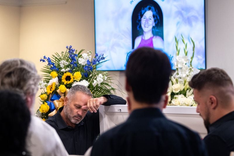 Dorin Irimie, husband of Ana Cristina Irimie, a math teacher killed at Apalachee High School during a school shooting, mourns by her casket at her funeral service at Hamilton Mill Memorial Chapel and Gardens in Buford on Saturday, September 14, 2024. (Arvin Temkar / AJC)