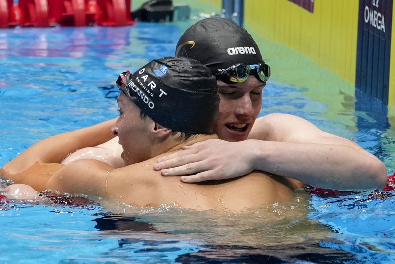 Luca Urlando and Thomas Heilman embraceafter the Men's 200 butterfly finals Wednesday, June 19, 2024, at the US Swimming Olympic Trials in Indianapolis. (AP Photo/Darron Cummings)