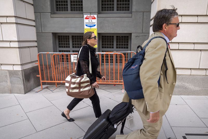 Kellye SoRelle, former general counsel for the Oath Keepers, left, and her attorney Horatio Aldredge leave federal court in Washington, Wednesday, Aug. 21, 2024. (AP Photo/Mark Schiefelbein)