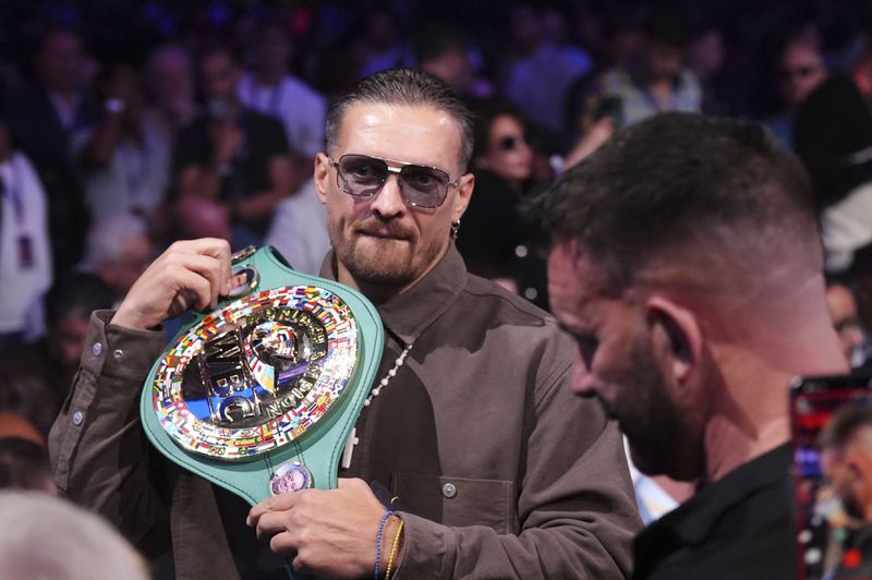 Ukrainian boxer Oleksandr Usyk in the stands with his belt at Wembley Stadium, in London, Saturday, Sept. 21, 2024. (Bradley Collyer/PA via AP)