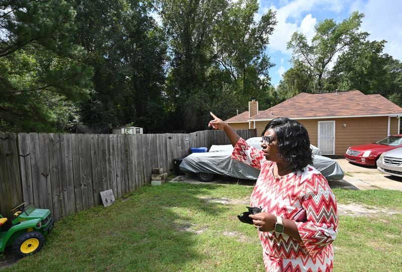 Deandra Bradley shows the proximity to Carver Park from her backyard in Columbus. Bradley says she hears gunshots from the park and says she's had to teach her children to move away from windows and drop to the floor when they hear firearms.(Hyosub Shin / Hyosub.Shin@ajc.com)