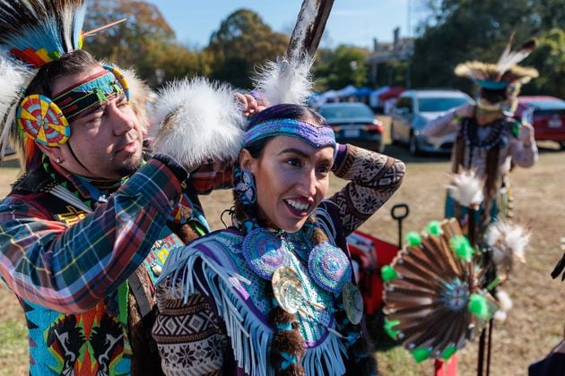 Violet Lauren of Atlanta, a member of the Chickasaw and Cherokee Nations, gets help adjusting her wardrobe before dancing at the inaugural First Voices Festival and powwow in Little Five Points in Atlanta on Saturday, Nov. 19, 2022. Reinhardt University researchers are transcribing property claims filed by Cherokee Indians during the 19th century, illuminating their plight during their forced removal from their homelands in Georgia. (Arvin Temkar / arvin.temkar@ajc.com)