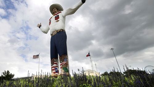 FILE - Bluebonnets, the state flower of Texas, surround Big Tex as storm clouds move in above, Friday, Sept. 27, 2013, in Dallas. (AP Photo/Tony Gutierrez, File)