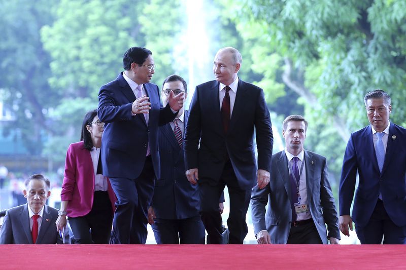 Vietnamese Prime Minister Pham Minh Chinh, front left, and Russian President Vladimir Putin, front right, talk as they walk into the government office in Hanoi, Vietnam Thursday, June 20, 2024. (Luoung Thai Linh/Pool Photo via AP)