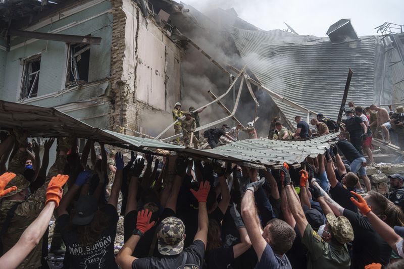 FILE - Rescuers work together to clear debris during a search operation for survivors at the Okhmatdyt children's hospital that was hit by a Russian missile, in Kyiv, Ukraine, July 8, 2024. (AP Photo/Evgeniy Maloletka, File)