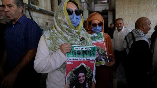 Two fellow activists of Aysenur Ezgi Eygi, 26, who was fatally shot by Israeli soldiers while participating in an anti-settlement protest in the West Bank, carry posters with her name and photo during Eygi's funeral procession in the West Bank city of Nablus, Monday, Sept. 9, 2024. (AP Photo/Nasser Nasser)