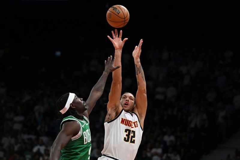 Denver Nuggets Aaron Gordon shoots over Boston Celtics Jrue Holiday during a preseason game between Boston Celtics and Denver Nuggets in Abu Dhabi, United Arab Emirates, Friday, Oct. 4, 2024. (AP Photo/Martin Dokoupil)