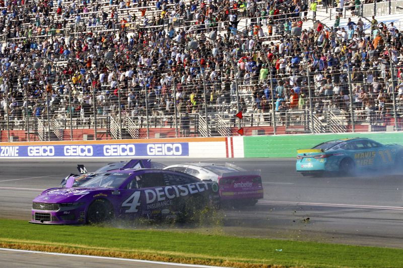 Josh Berry (4), Zane Smith (71) and Denny Hamlin (11) are involved in a wreck while coming out of Turn 4 during a NASCAR Cup Series auto race Sunday, Sept. 8, 2024, in Hampton, Ga. (AP Photo/Skip Williams)