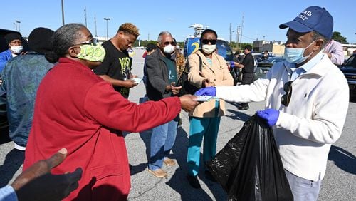 DeKalb County CEO Michael Thurmond hands COVID-19 care kits out to residents at Big Lots parking lot at 2738 Candler Road in Decatur on Saturday, May 9, 2020. (Hyosub Shin / Hyosub.Shin@ajc.com)