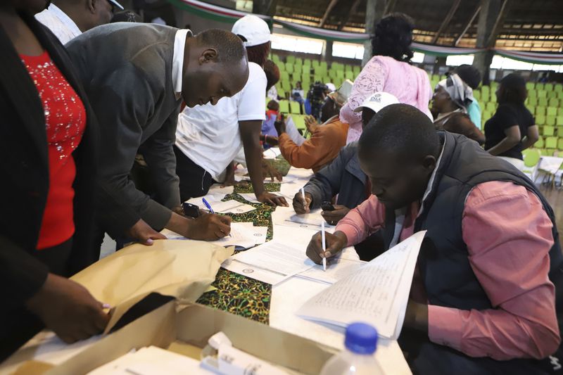 Members of the public fill out public participation forms at a public forum for an impeachment motion against Kenya's deputy president Rigathi Gachagua, at Bomas of Kenya, in Nairobi, Friday, Oct. 4, 2024. (AP Photo/Brian Inganga)