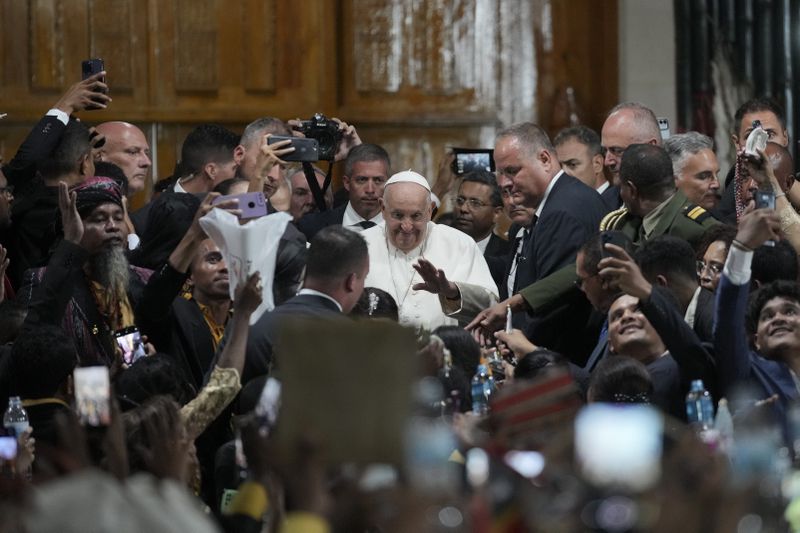 Pope Francis gestures as he is surrounded by attendees after a meeting at the Presidential Palace in Dili, East Timor, Monday, Sept. 9, 2024. (AP Photo/Dita Alangkara)