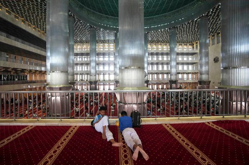 Indonesian students wait for the start of Friday prayers at Istiqlal Mosque in Jakarta, Indonesia, Friday, Aug. 9, 2024. (AP Photo/Tatan Syuflana)