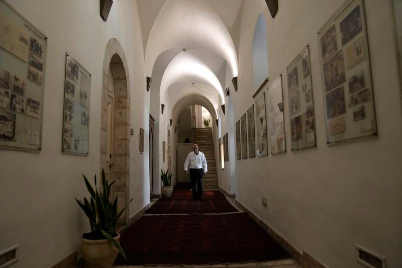 A worker walks in a corridor at the American Colony Hotel in east Jerusalem, Sunday, Aug. 18, 2024. As Israel’s economy is suffering from the nearly 11-month war with Hamas, Jerusalem’s iconic American Colony hotel has had to lay off workers and are mulling pay cuts, said Jeremy Berkovitz, the official representative of the owners. (AP Photo/Mahmoud Illean)