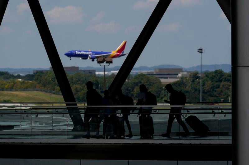 Travelers make their way into the Nashville International Airport, Friday, Aug. 30, 2024, in Nashville, Tenn. (AP Photo/George Walker IV)