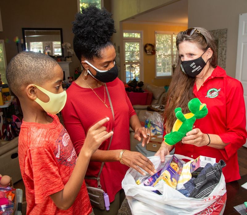 Neighbors Jason Williams (age 9) & his mother Erica talk with Marika Chasse in her Johns Creek home. For the past six years, the Chasses have hosted a packing party for Operation Christmas Child shoeboxes, a project of Samaritan's Purse. Friends and neighbors will help pack 1,000 shoeboxes. PHIL SKINNER FOR THE ATLANTA JOURNAL-CONSTITUTION.