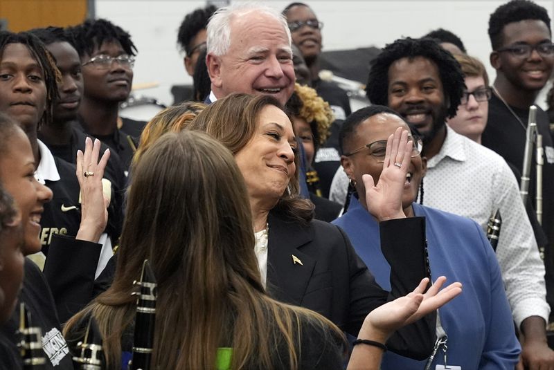 Democratic presidential nominee Vice President Kamala Harris and Democratic vice presidential candidate Minnesota Gov. Tim Walz pose for a photo with marching band members at Liberty County High School in Hinesville, Ga., Wednesday, Aug. 28, 2024. (AP Photo/Jacquelyn Martin)