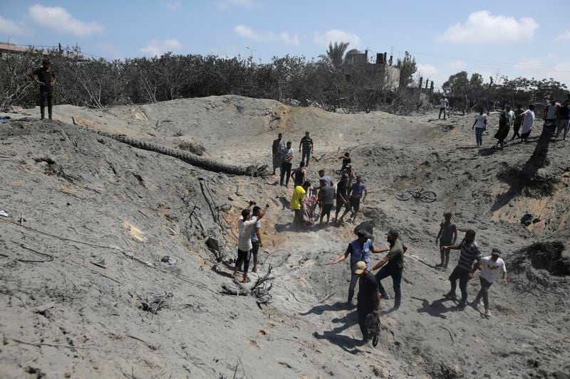 Palestinians search for bodies and survivors in a site hit by an Israeli bombardment on Khan Younis, southern Gaza Strip, Saturday, July 13, 2024. Israel said it targeted Hamas’ shadowy military commander in a massive strike Saturday in the crowded southern Gaza Strip that killed at least 71 people, according to local health officials. Hamas immediately rejected the claim that Mohammed Deif was in the area. (AP Photo/Jehad Alshrafi)