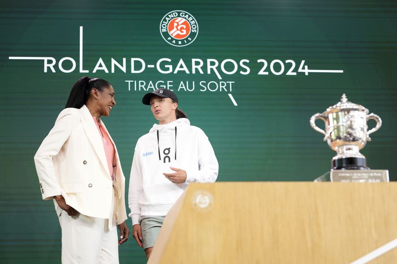 Former French athletic champion Marie-Jose Perec, left, talks with titleholder Poland's Iga Swiatek during the draw for the French Tennis Open at the Roland Garros stadium, Thursday, May 23, 2024 in Paris. The tournament starts Sunday May 26, 2024. (AP Photo/Thibault Camus)