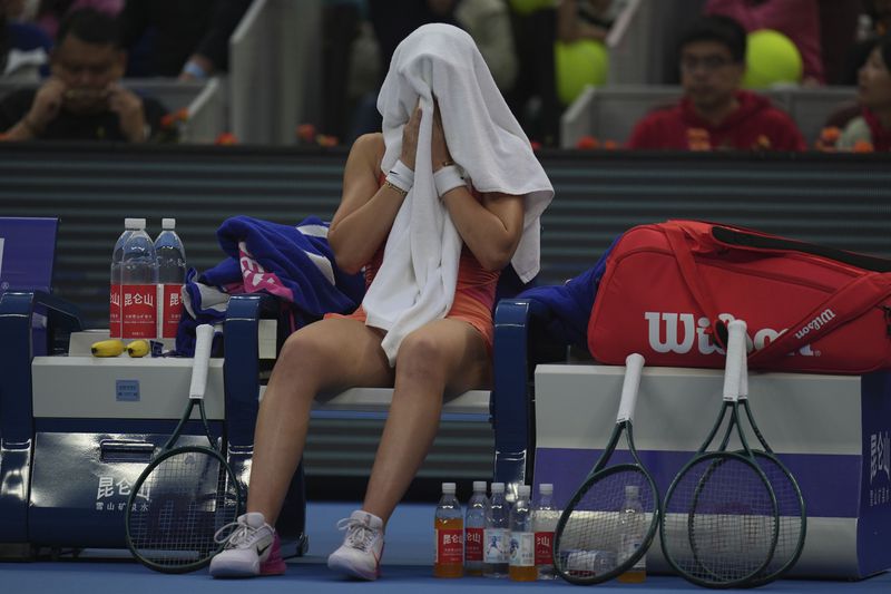 Paula Badosa of Spain cover herself with a towel during sets against Coco Gauff of the United States in a women's singles semi-final match for the China Open tennis tournament held at the National Tennis Center in Beijing, Saturday, Oct. 5, 2024. (AP Photo/Ng Han Guan)