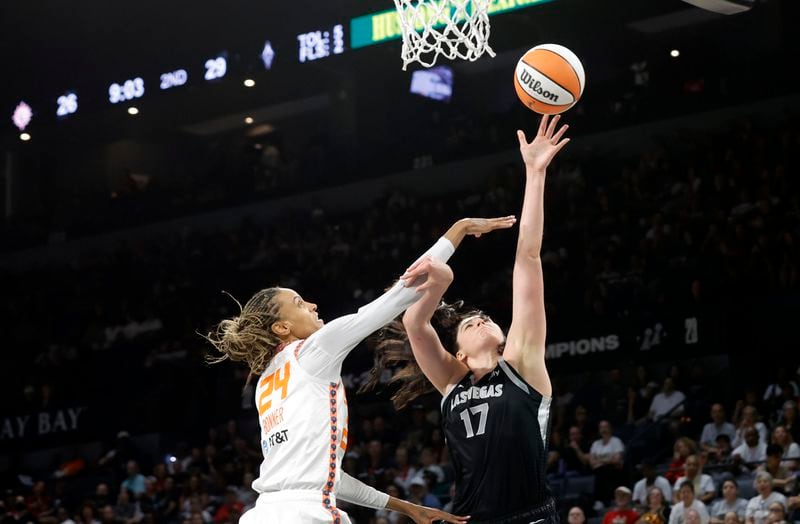 Las Vegas Aces center Megan Gustafson (17) shoots a layup against Connecticut Sun forward DeWanna Bonner (24) during the first half of an WNBA basketball game Sunday, Sept. 15, 2024, in Las Vegas. (Steve Marcus/Las Vegas Sun via AP)