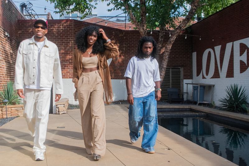 From left, Tunde Balogun, CEO of Love Renaissance, Amber Grimes, executive vice president and general manager, and Justice Baiden, head of A&R, take a walk after an Atlanta meeting. (Ziyu Julian Zhu/AJC)