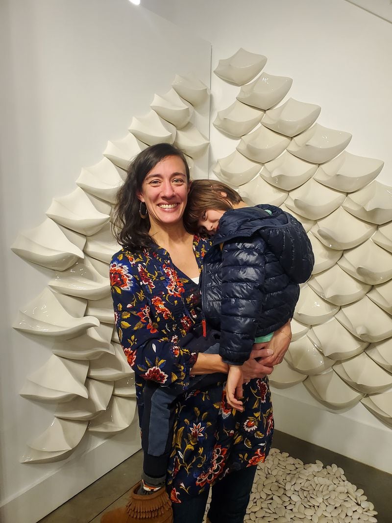 Rachel Garceau and her son stand in front of her piece, "Methods of Embrace." (Photo Courtesy of Jayla McDaniel/Fresh Take Georgia)