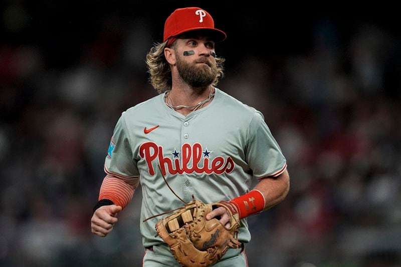 Philadelphia Phillies first baseman Bryce Harper (3) runs to the dugout in the fifth inning of a baseball game against the Atlanta Braves, Tuesday, Aug. 20, 2024, in Atlanta. (AP Photo/Mike Stewart)