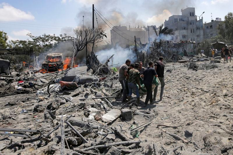 Palestinians evacuate a body from a site hit by an Israeli bombardment on Khan Younis, southern Gaza Strip, Saturday, July 13, 2024. Israel said it targeted Hamas' shadowy military commander in a massive strike Saturday in the crowded southern Gaza Strip that killed at least 71 people, according to local health officials. Hamas immediately rejected the claim that Mohammed Deif was targeted. (AP Photo/Jehad Alshrafi)