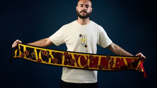 Atlanta United’s Derrick Williams unfurls the team’s Juneteenth scarf, which is part of the Legacy Collection.