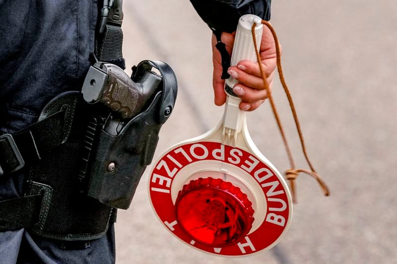 A German police officer prepares to stop a bus at the border between Germany and France, in Kehl, Germany, Monday, Sept. 16, 2024, as Germany begins carrying out checks at all its land borders. (AP Photo/Michael Probst)