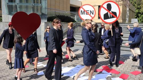 Kirsha Kaechele, curator of a ladies' lounge at Tasmania's Museum of Old and New Art, back center, and supporters dance outside the Supreme Court of Tasmania in Hobart, Australia, Friday, Sept. 27, 2024. (Ethan James/AAP Image via AP)