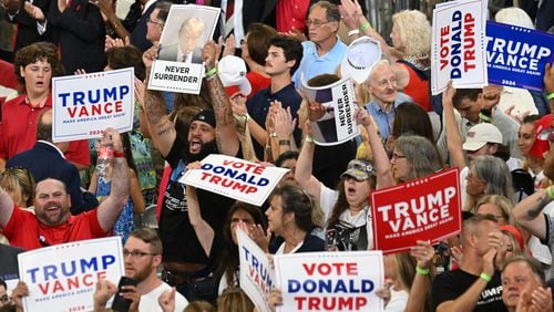 Supporters hold signs to show their supports during a rally at Georgia State University’s convocation center on Saturday, August 3, 2024 in Atlanta. Former President Donald Trump and vice-presidential candidate JD Vance are holding their first rally together in Georgia on Saturday at the same place – the GSU Convocation Center- Kamala Harris held hers earlier this week.  (Hyosub Shin / AJC)