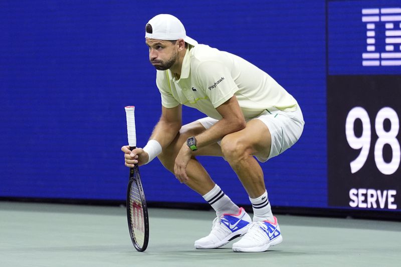 Grigor Dimitrov, of Bulgaria, reacts with an apparent injury shortly before he was forced to retire in his match against Frances Tiafoe, of the United States, during the quarterfinals of the U.S. Open tennis championships, Tuesday, Sept. 3, 2024, in New York. (AP Photo/Eduardo Munoz Alvarez)