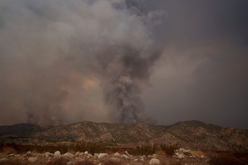 Smoke from the advancing Line Fire rises above a ridge in Mentone in San Bernardino County, Calif., Sunday, Sept. 8, 2024. (AP Photo/Eric Thayer)