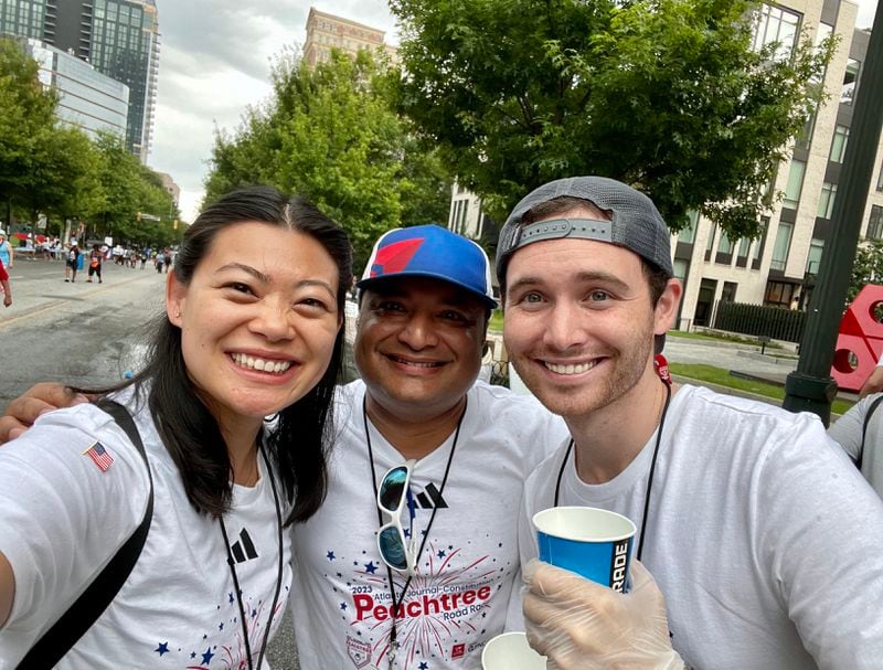Delta Air Lines employees Wenya Lee (left), Saif Khan (middle) and James Kroeger (right), volunteer at the Peachtree Road Race in 2023. Courtesy of Delta