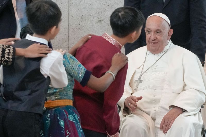 Pope Francis is welcomed by dancing children as he arrives at Singapore Changi International Airport, Wednesday, Sept. 11, 2024. Pope Francis is heading to Singapore for the final leg of his 11-day trip to Asia and Oceania. (AP Photo/Gregorio Borgia)