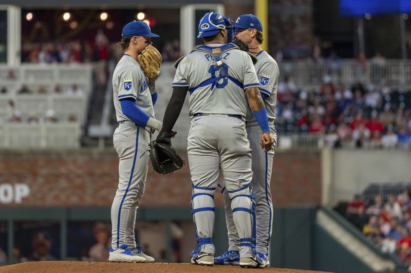 Kansas City Royals shortstop Bobby Witt Jr., left, pitcher Brady Singer, center, and catcher Salvador Perez, right, meet at the mound in the first inning of a baseball game against the Atlanta Braves, Friday, Sept. 27, 2024, in Atlanta. (AP Photo/Jason Allen)