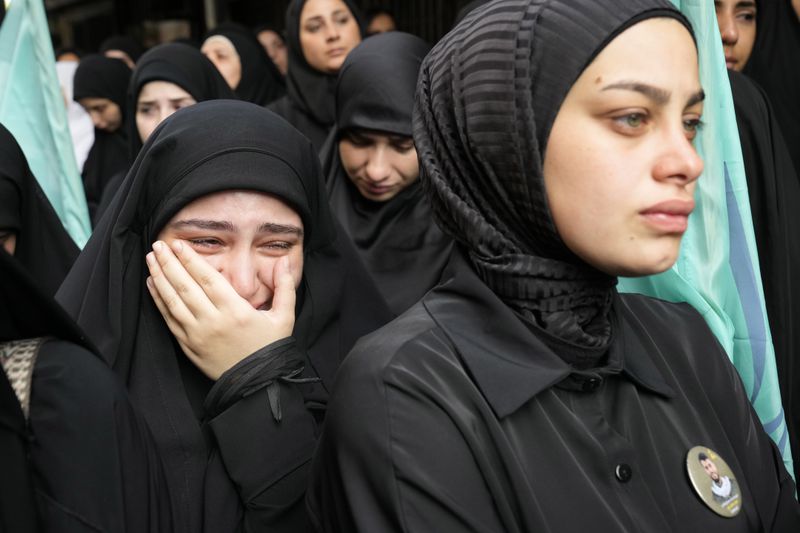 A girl cries during the funeral procession of two Hezbollah members, killed on Wednesday when a handheld device exploded, in the southern suburbs of Beirut, Thursday, Sept. 19, 2024. (AP Photo/Hussein Malla)