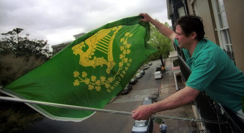 Lou Thomann flies his St. Patrick's Day flag off the third-floor balcony of his inn in Savannah, the Suites of Lafayette, in preparation for the 2001 celebration. (AP Photo/Stephen Morton).