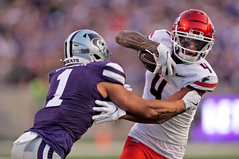 Arizona wide receiver Tetairoa McMillan (4) tries to get past Kansas State cornerback Keenan Garber (1) during the first half of an NCAA college football game Friday, Sept. 13, 2024, in Manhattan, Kan. (AP Photo/Charlie Riedel)