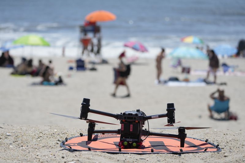 A drone with emergency flotation devices attached prepares to launch at Rockaway Beach in New York, Thursday, July 11, 2024. A fleet of drones patrolling New York City’s beaches for signs of sharks and struggling swimmers is drawing backlash from an aggressive group of seaside residents: local shorebirds. Since the drones began flying in May, flocks of birds have repeatedly swarmed the devices, forcing the police department and other city agencies to adjust their flight plans. (AP Photo/Seth Wenig)