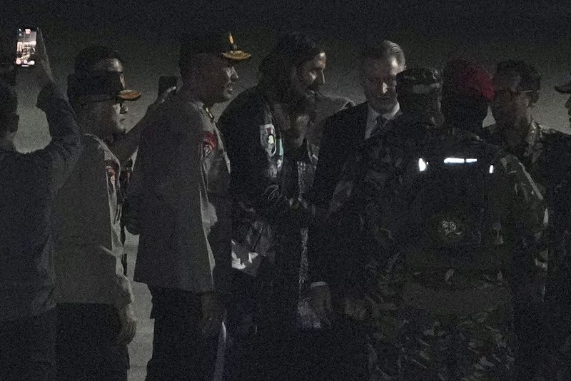 The New Zealand pilot who was held hostage for more than a year by separatist rebels in the Papua region, Phillip Mark Mehrtens, center, is greeted by New Zealand Ambassador to Indonesia Kevin Burnett and Indonesian officials upon arrival at Halim Perdanakusuma Air Base in Jakarta, Indonesia, Saturday, Sept. 21, 2024. (AP Photo/Achmad Ibrahim)