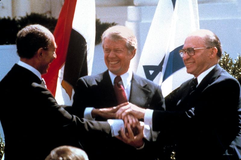 FILE - Egyptian President Anwar Sadat, left, U.S. President Jimmy Carter, center, and Israeli Prime Minister Menachem Begin clasp hands on the North lawn of the White House as they completed signing of the peace treaty between Egypt and Israel in Washington on March, 26, 1979. (AP Photo/Bob Daugherty, File)