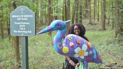 Young artist Cameron Jefferies poses with the blue heron statue inspired by her design. Jefferies incorporated the city of Conyers logo in her design. (Photo Courtesy of Alice Queen)