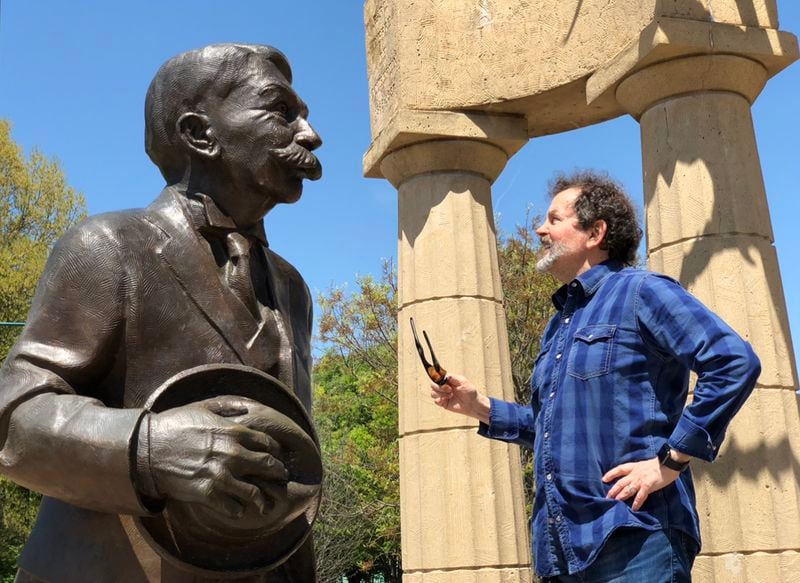 George Hirthler stands with the Coubertin statue in Centennial Olympic Park.