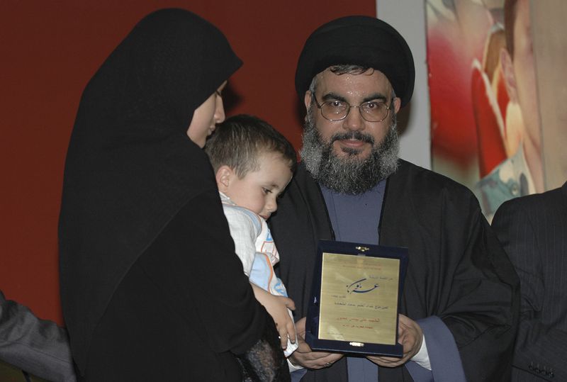 FILE - Hezbollah leader Hassan Nasrallah, hands a certificate to the wife of a slain Hezbollah fighter during a ceremony in Beirut's southern suburbs, Sunday April 8, 2007. (AP Photo, File)